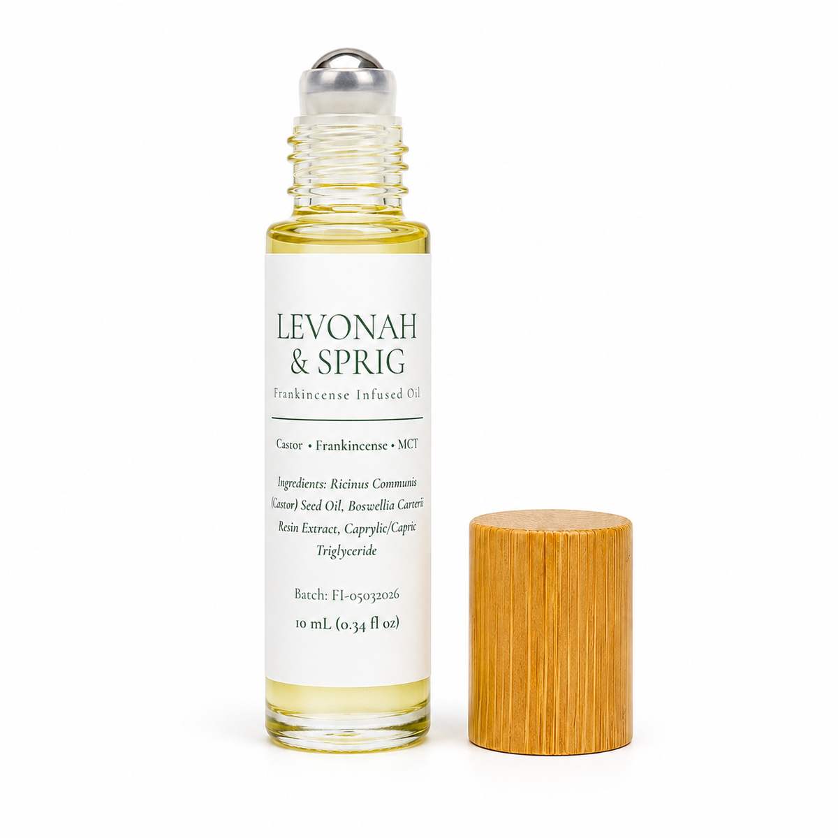 A 10 mL glass bottle of Levonah & Sprig Frankincense Infused Oil with a white label and silver roller cap, shown next to its light brown bamboo cap on a white background.